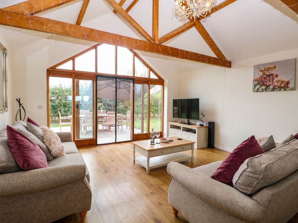 A living room with two sofas and a television at The Mulberry, nr Bungay