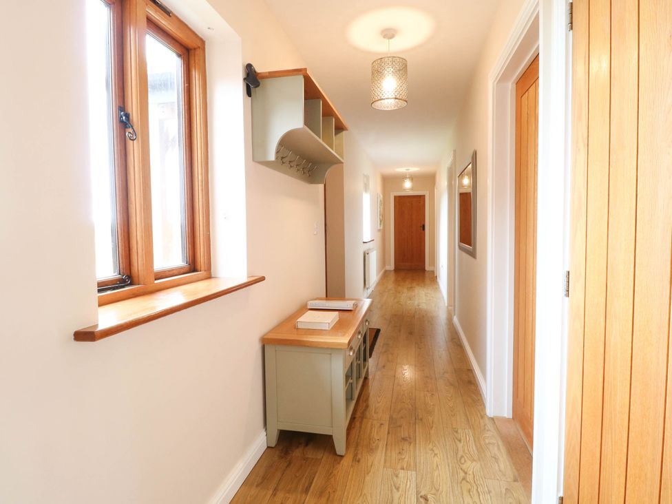 A hallway with a window, bench, and coat rack at The Mulberry, nr Bungay Bungay