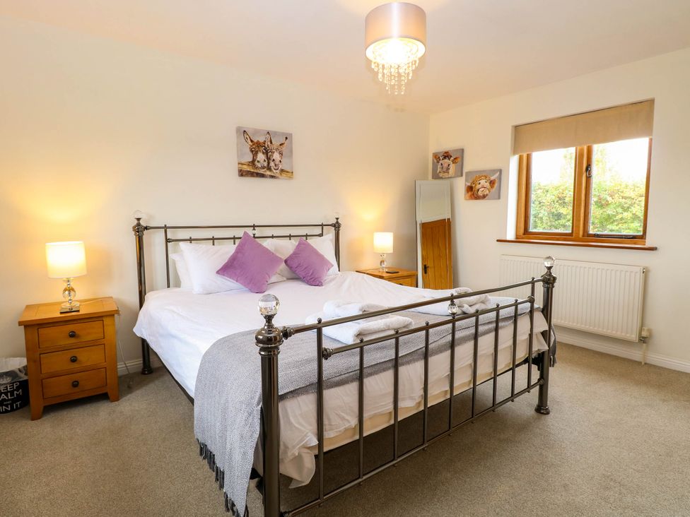 A bedroom with a bed and bedside table at The Mulberry, nr Bungay