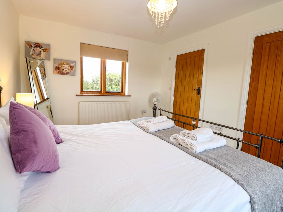 A bedroom with a bed and decorative items at The Mulberry, nr Bungay in Bungay