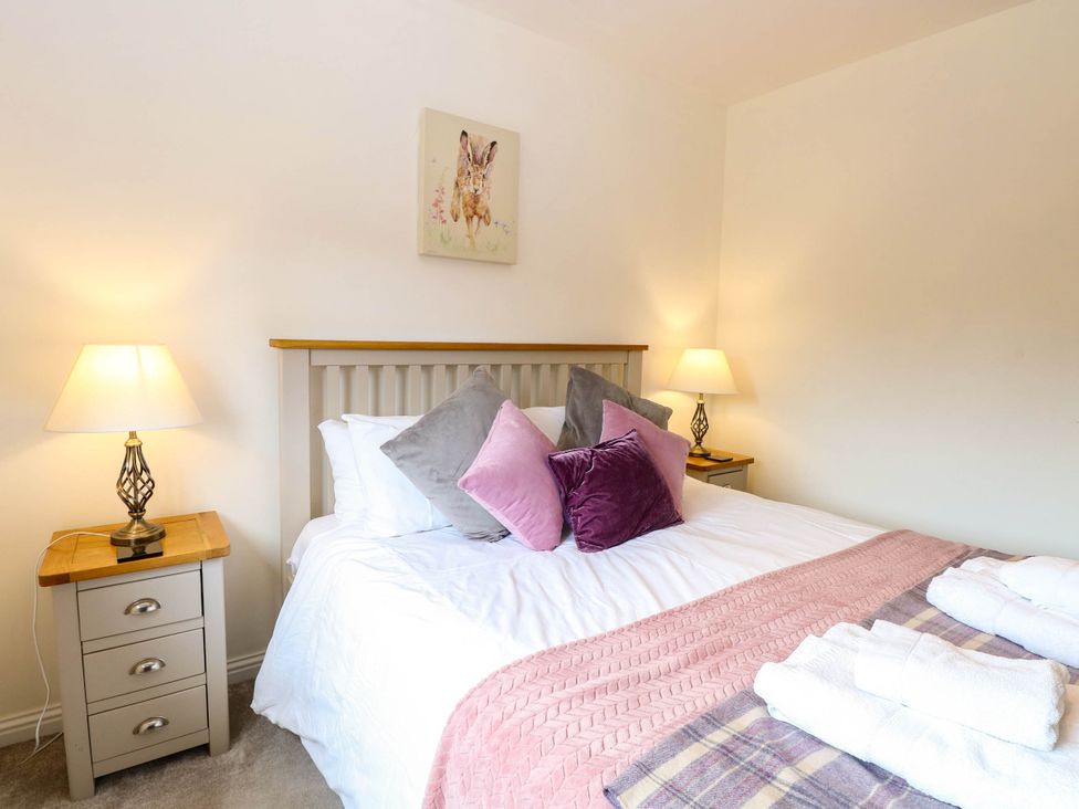A bedroom with a bed and bedside tables at The Mulberry, nr Bungay