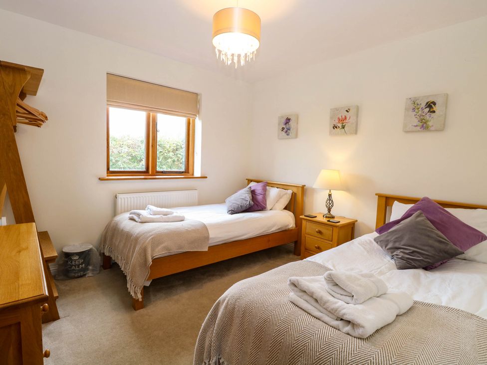 A bedroom with two beds and a window at The Mulberry, nr Bungay