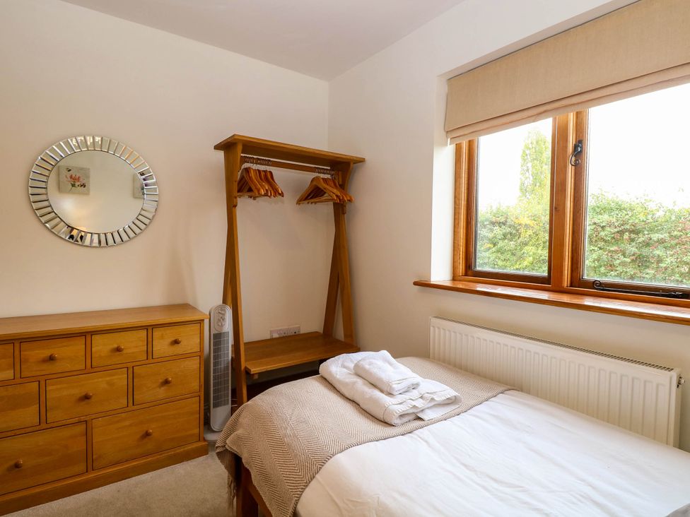 A bedroom with a bed and dresser at The Mulberry, nr Bungay