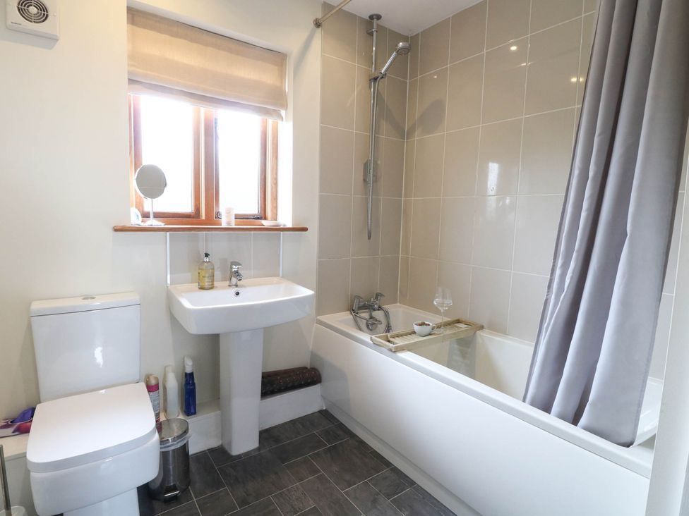 A bathroom with a toilet, sink, and bathtub at The Mulberry, nr Bungay