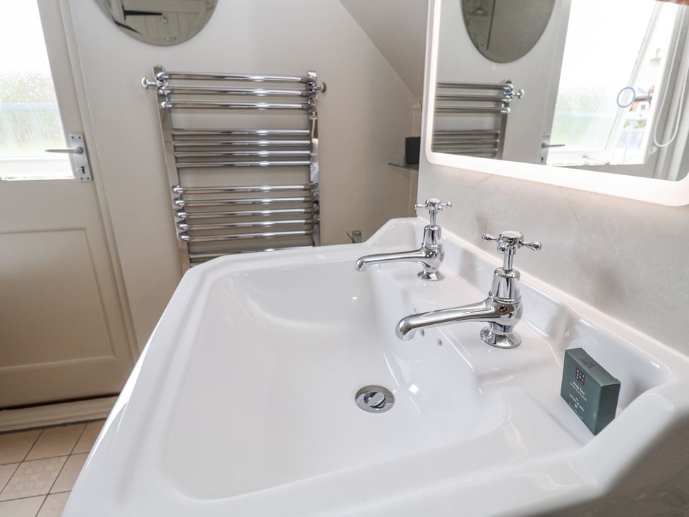 A bathroom with a double sink and mirror at Mariners Cottage, King Street, Aldeburgh