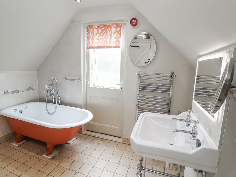 A bathroom with a bathtub and washbasin at Mariners Cottage, King Street, Aldeburgh