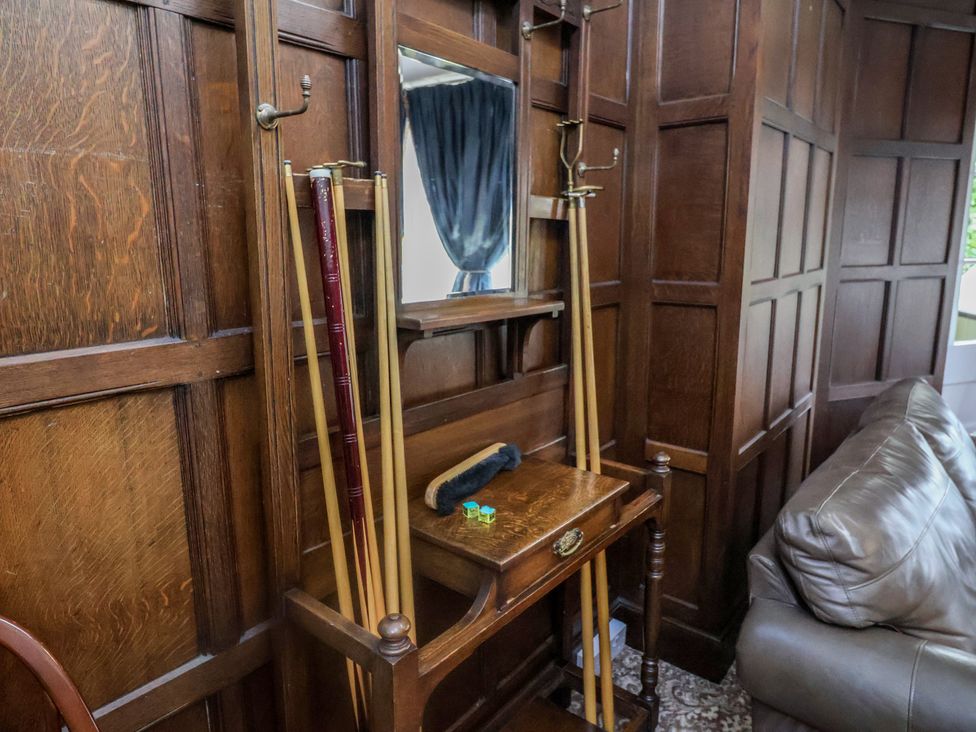 A living room with a coat rack and wooden table at Henstead Hall in Henstead near Beccles