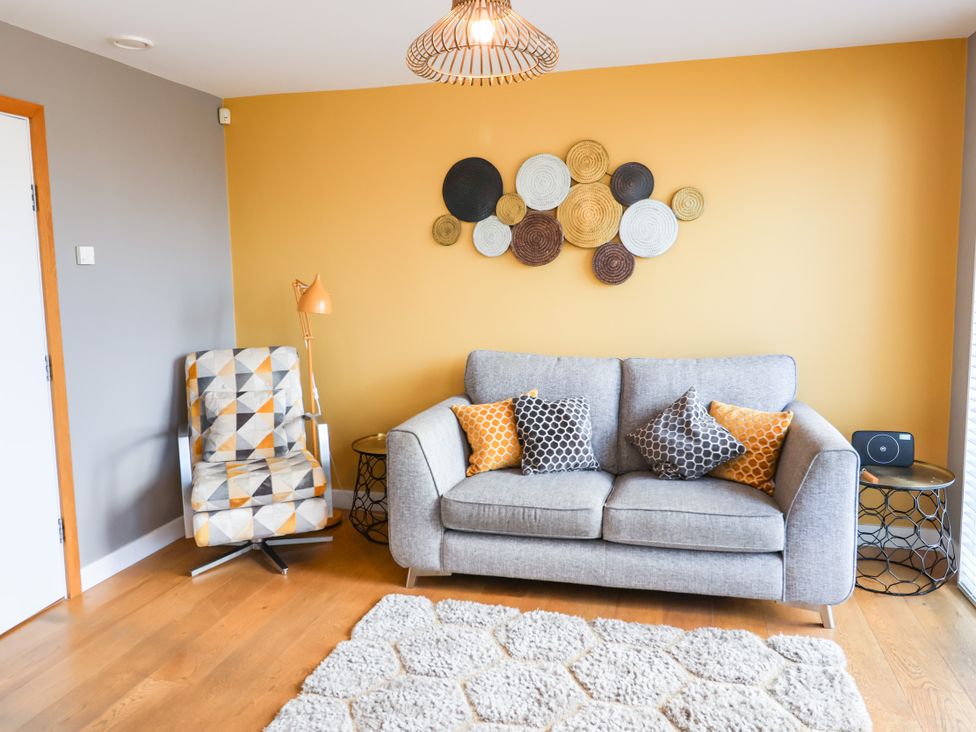 A living room with a sofa and armchair at The Hive in Southwold