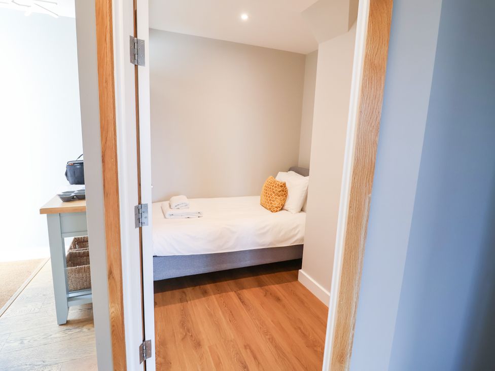 A bedroom with a bed and table at The Hive, Southwold