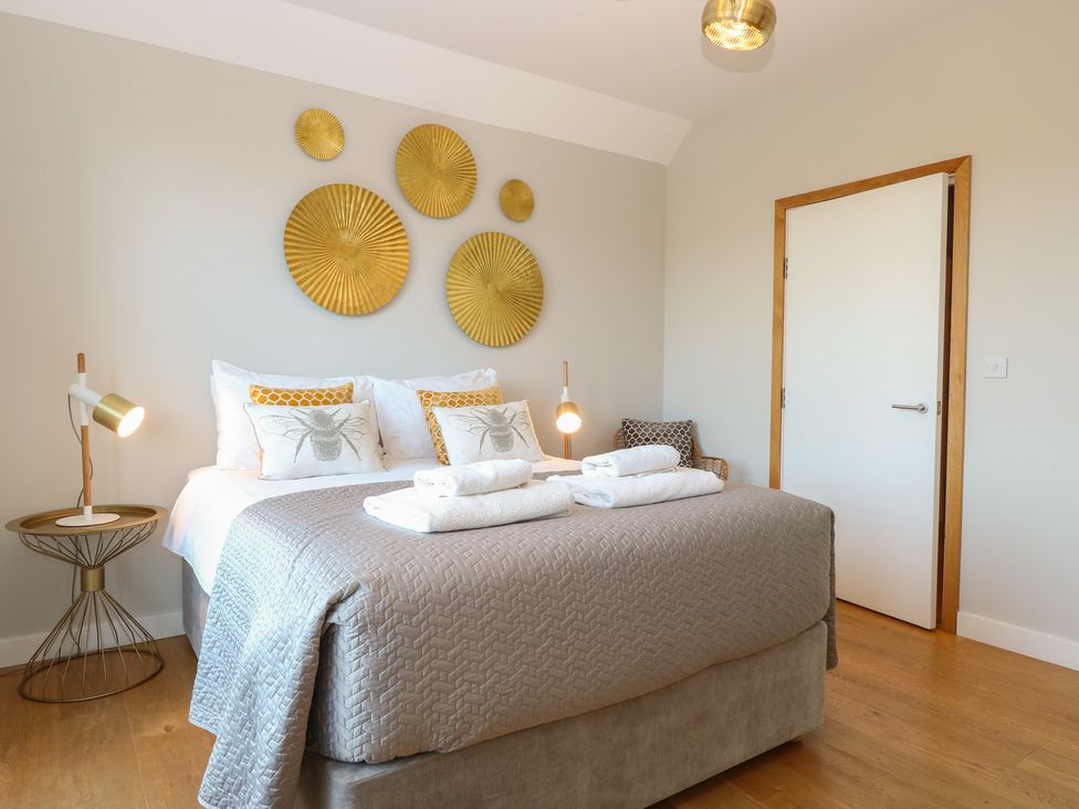 A bedroom with a bed and wall decor at The Hive, Southwold