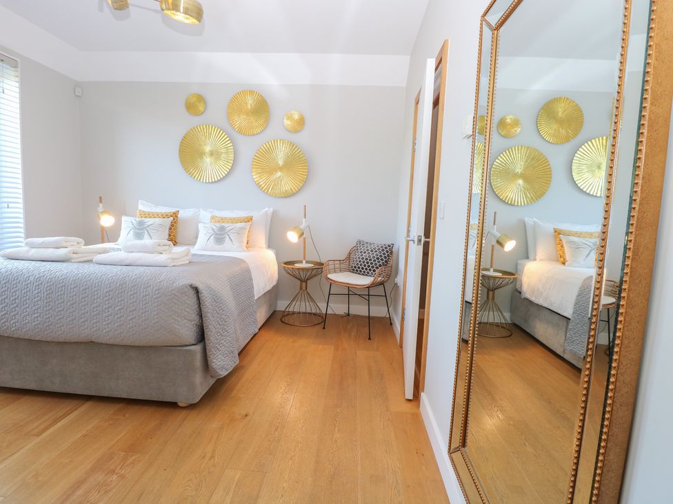 A bedroom with a bed and artworks on the wall at The Hive, Southwold
