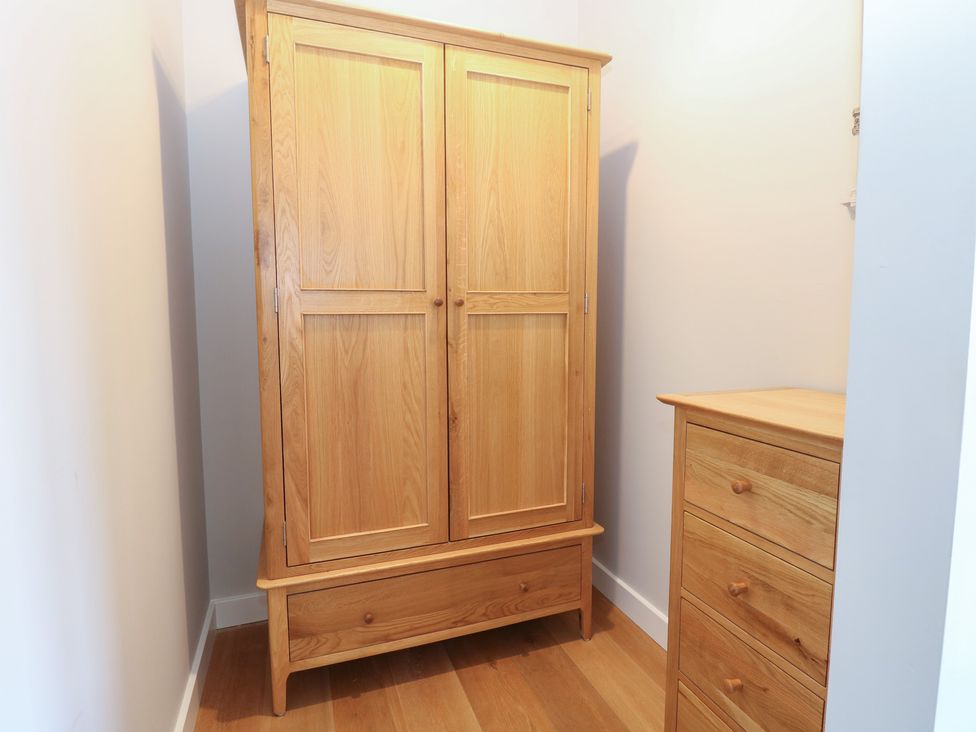 A wardrobe and a chest of drawers in a bedroom at The Hive, Southwold