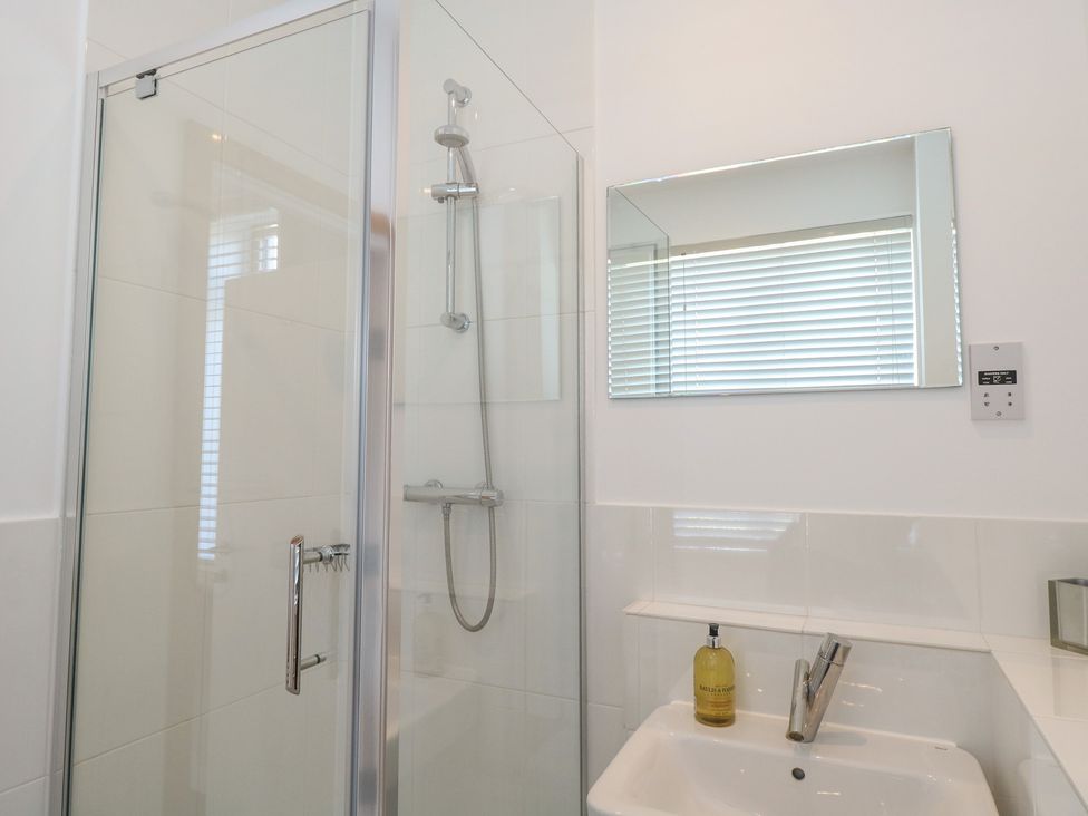 A bathroom with a shower and sink at The Hive, Southwold