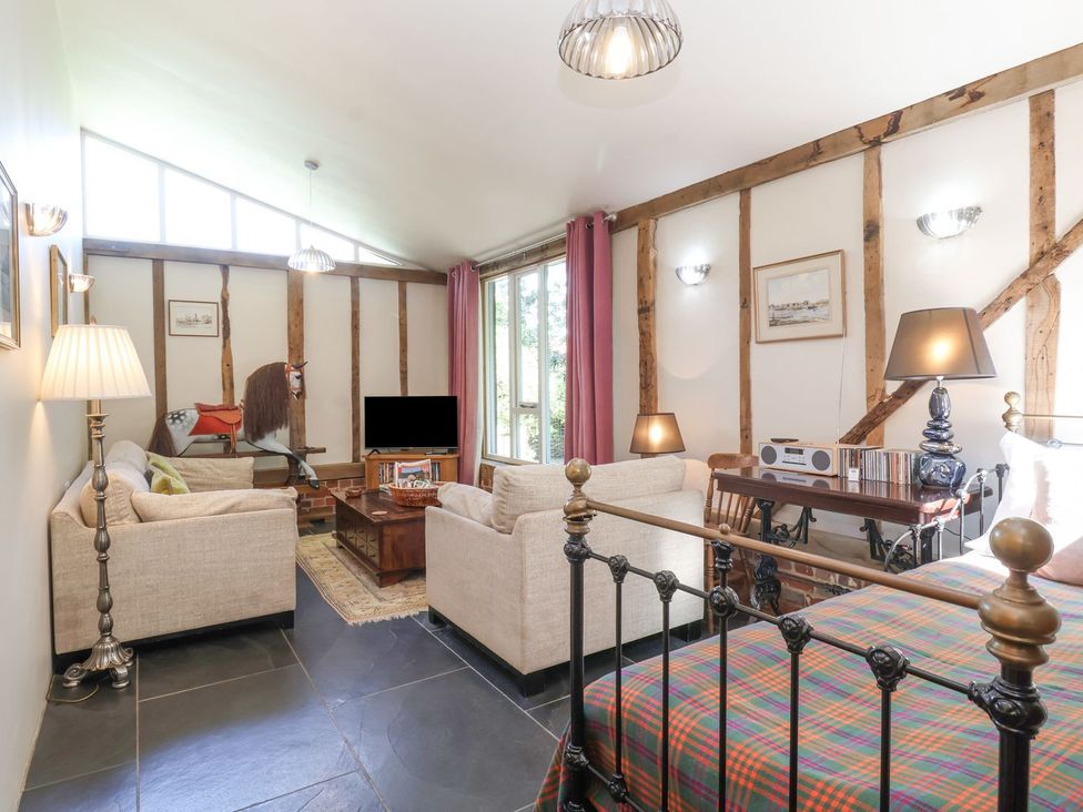 A living room with a TV and sofa at Yew Tree Farm Barn and Stable in Framlingham