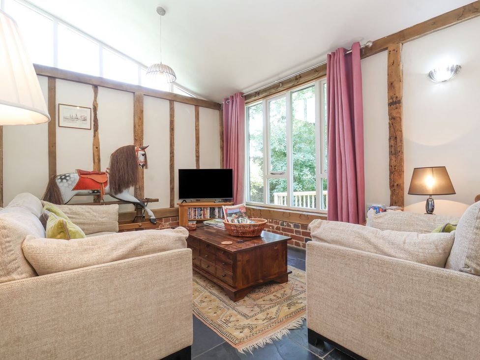 A living room with a coffee table and a television at Yew Tree Farm Barn and Stable in Framlingham