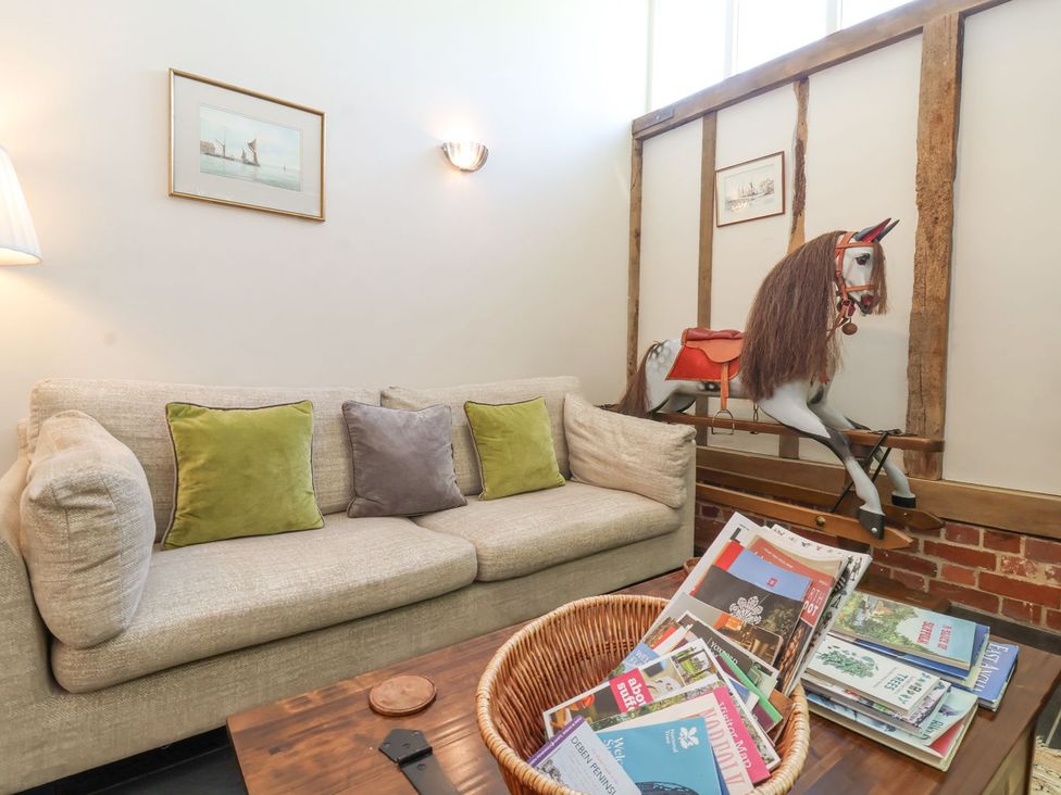 A living room with a sofa and horse decoration at Yew Tree Farm Barn and Stable Framlingham