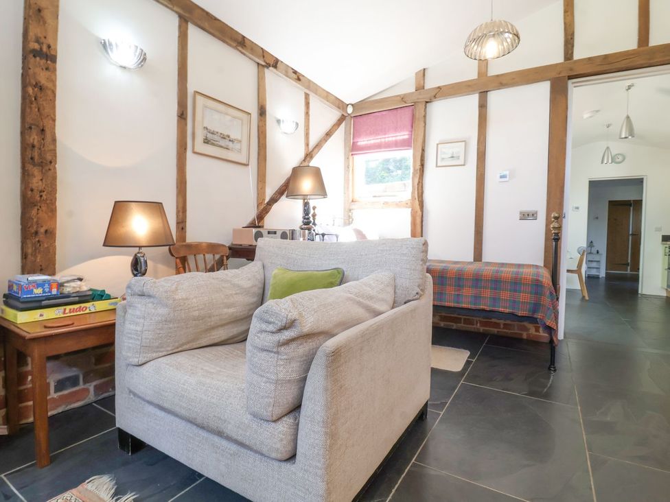 A living room with a sofa and a lamp at Yew Tree Farm Barn and Stable Framlingham