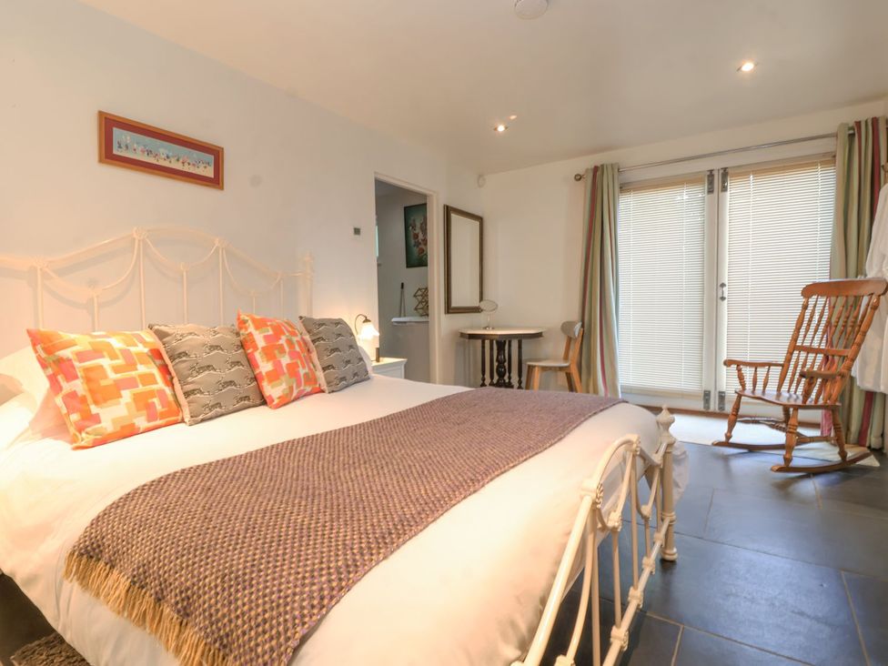 A bedroom with a bed and a rocking chair at Yew Tree Farm Barn and Stable Framlingham