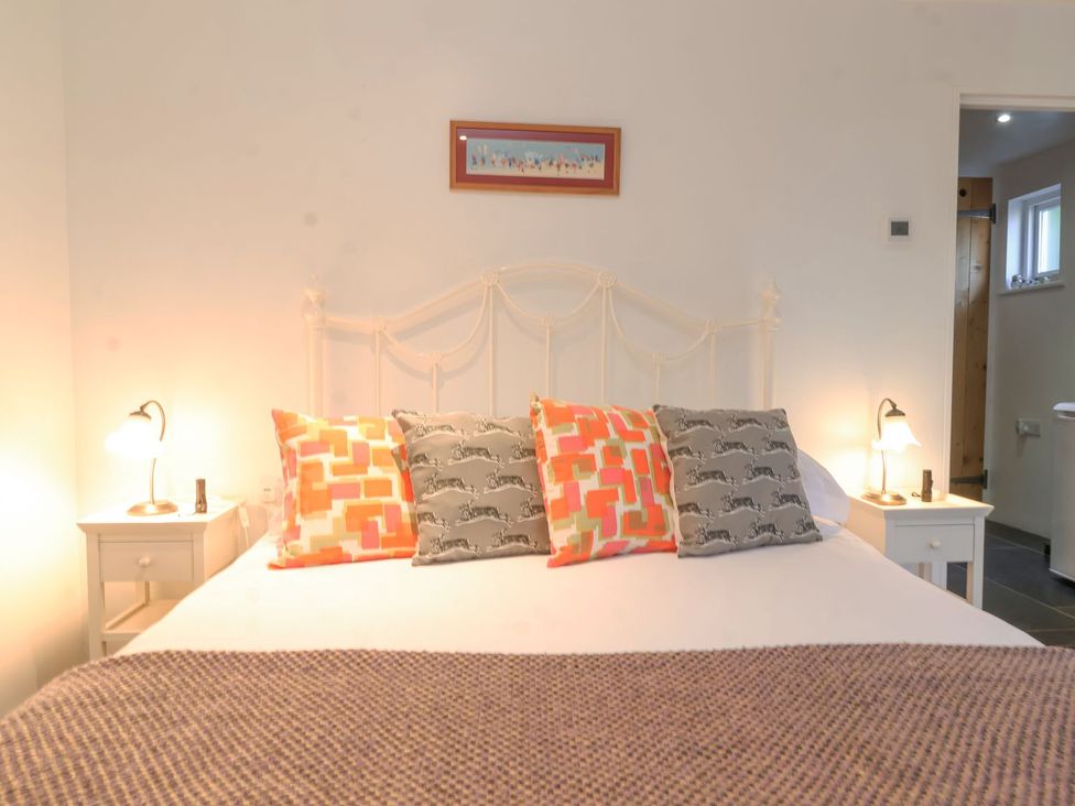 A bedroom with a bed and bedside tables at Yew Tree Farm Barn and Stable Framlingham
