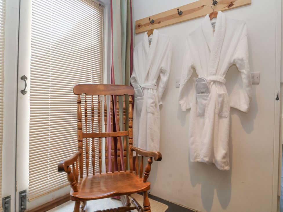 A rocking chair and two robes hanging on hooks at Yew Tree Farm Barn and Stable in Framlingham