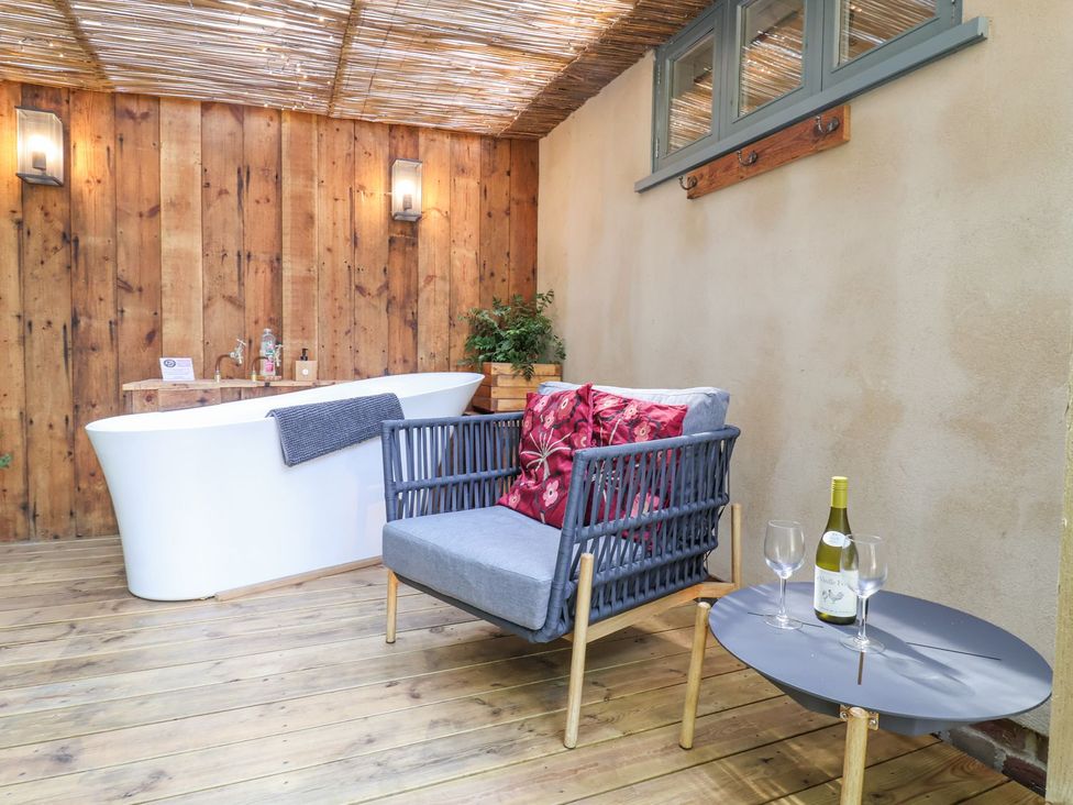 A relaxation area with a bathtub and seating at Yew Tree Farm Barn and Stable in Framlingham