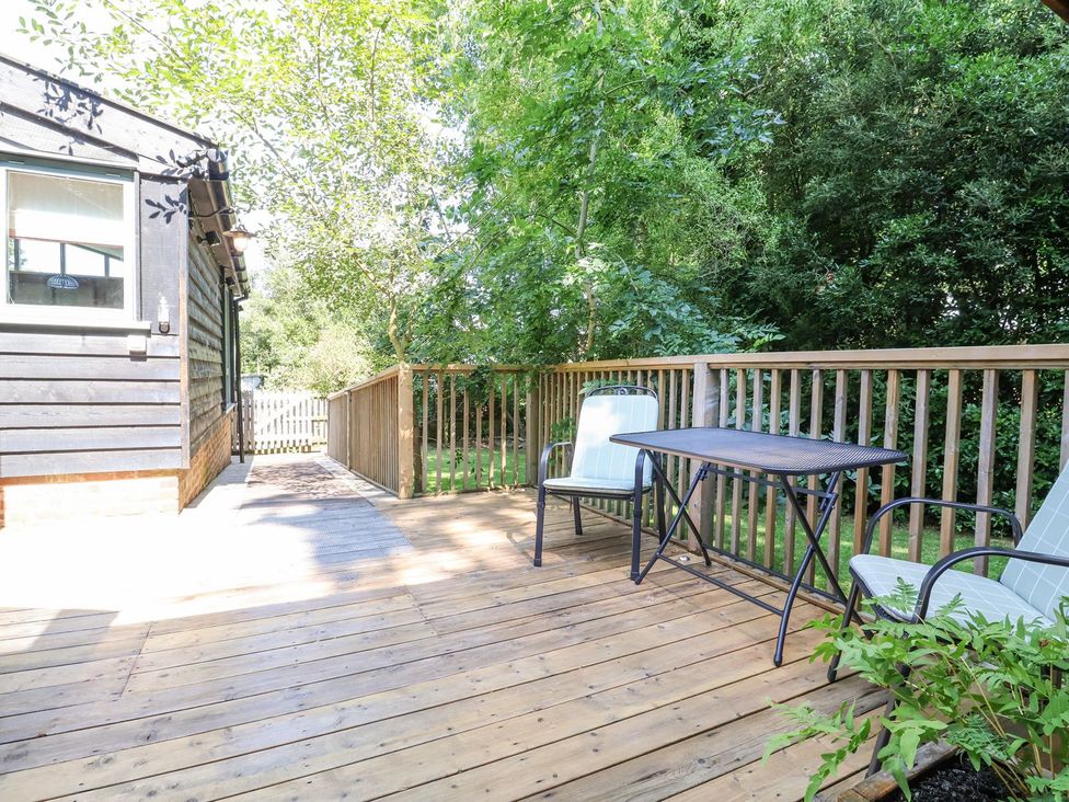 An outdoor deck with a table and chairs at Yew Tree Farm Barn and Stable Framlingham
