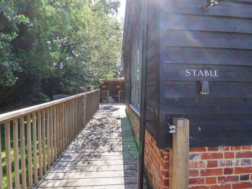 A stable with a wooden walkway leading to it at Yew Tree Farm Barn and Stable in Framlingham