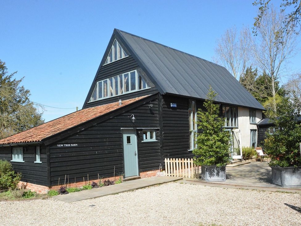 A barn with large windows and a pathway at Yew Tree Farm Barn and Stable Framlingham