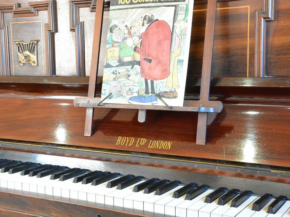 A piano with a music sheet holder and sheet music at Yew Tree Farm Barn and Stable Framlingham