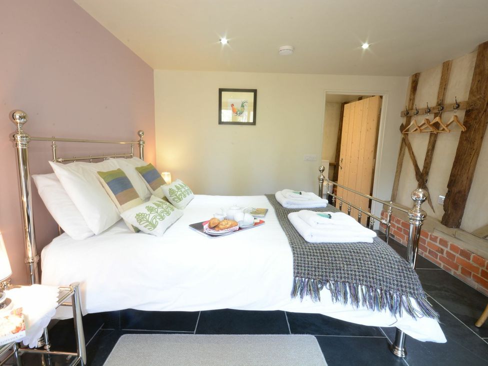 A bedroom with a bed and breakfast items at Yew Tree Farm Barn and Stable in Framlingham