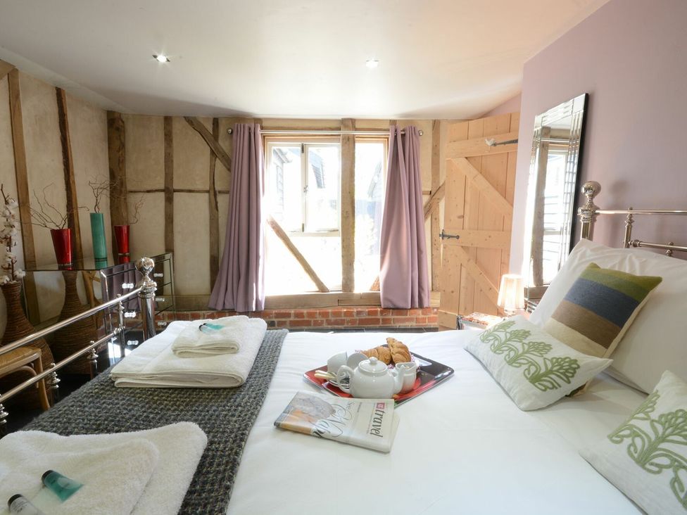 A bedroom with a bed and tea set at Yew Tree Farm Barn and Stable in Framlingham