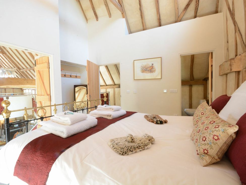 A bedroom with a bed and towels at Yew Tree Farm Barn and Stable Framlingham