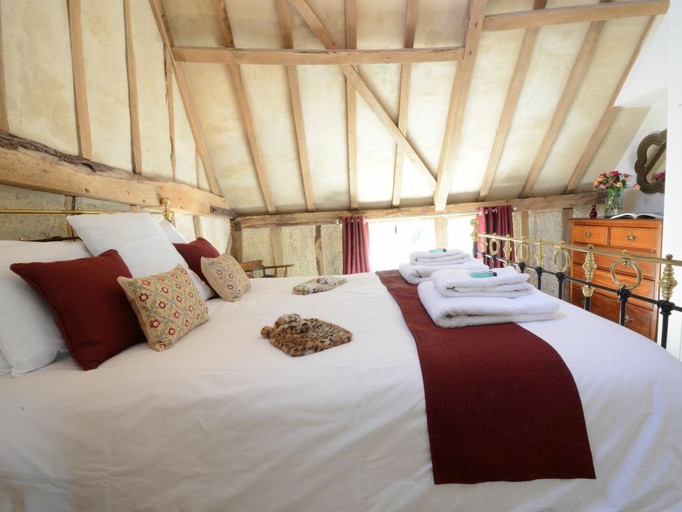 A bedroom with a bed and towels at Yew Tree Farm Barn and Stable in Framlingham