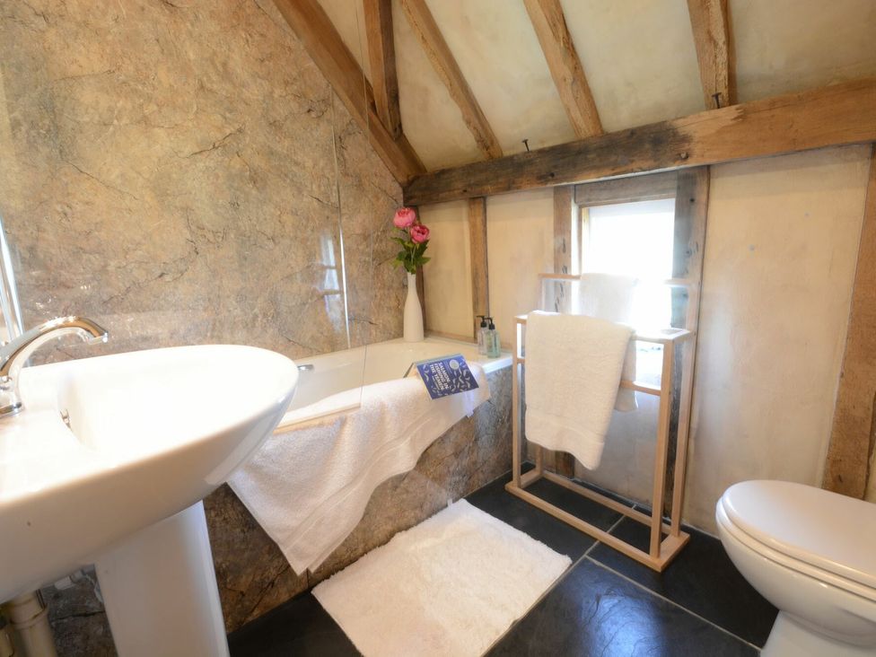 A bathroom featuring a bathtub, sink, and towel rack at Yew Tree Farm Barn and Stable in Framlingham