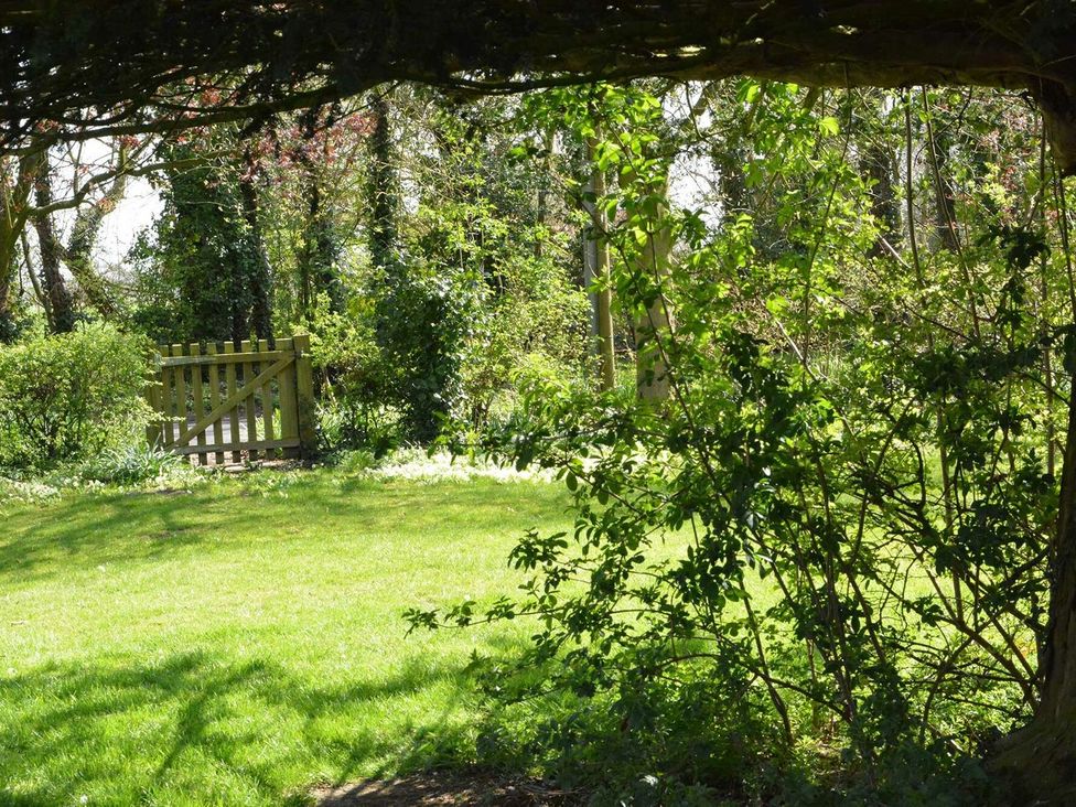 A garden with a gate and grass at Yew Tree Farm Barn and Stable in Framlingham