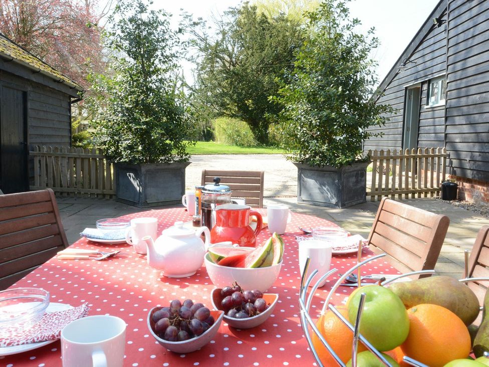 An outdoor dining table set with fruit and drinks at Yew Tree Farm Barn and Stable Framlingham