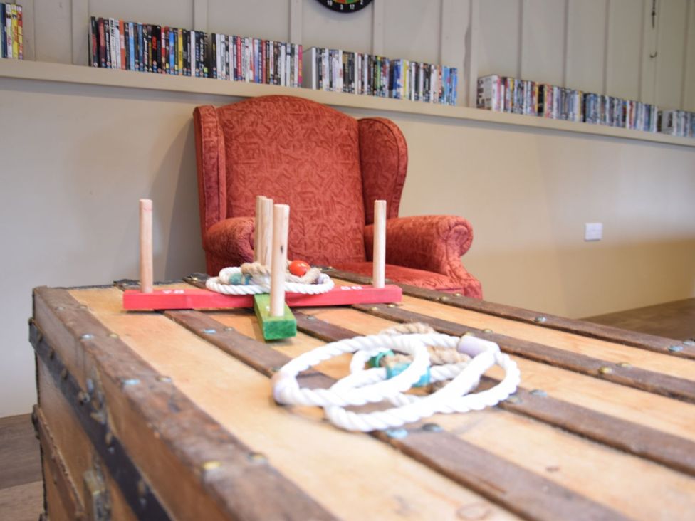 A game room with an armchair and a wooden chest at Yew Tree Farm Barn and Stable Framlingham