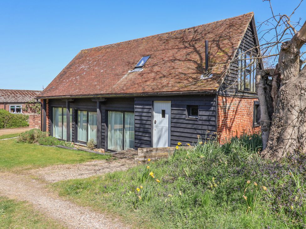 A house with a sloped roof and windows at The Cart House in Sudbourne Near Orford