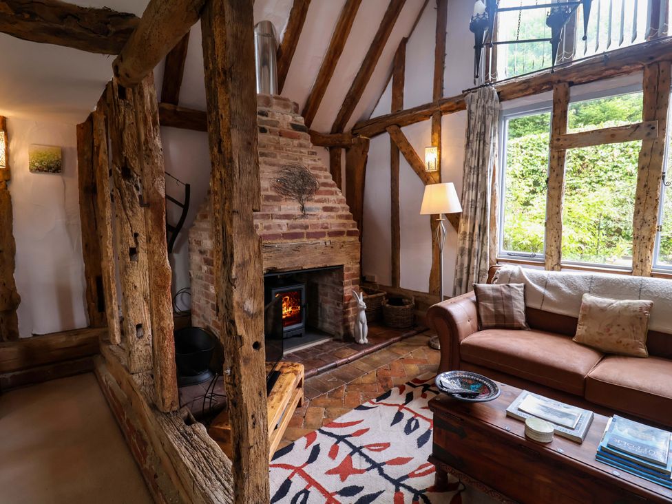 A living room with a fireplace and sofa at Wassicks Cottage, Haughley