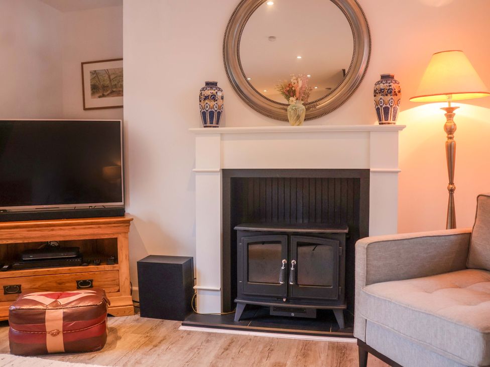 A living room with a sofa and television at Pine Cottage in Woodbridge