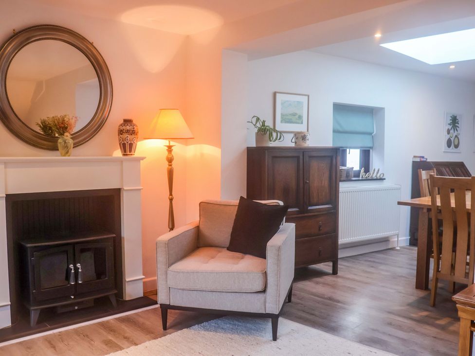 A living room with a fireplace and seating at Pine Cottage in Woodbridge