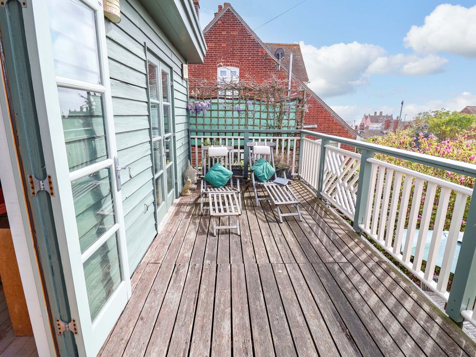 An outdoor deck with chairs and plant at Robert Sadler's Studio in Aldeburgh