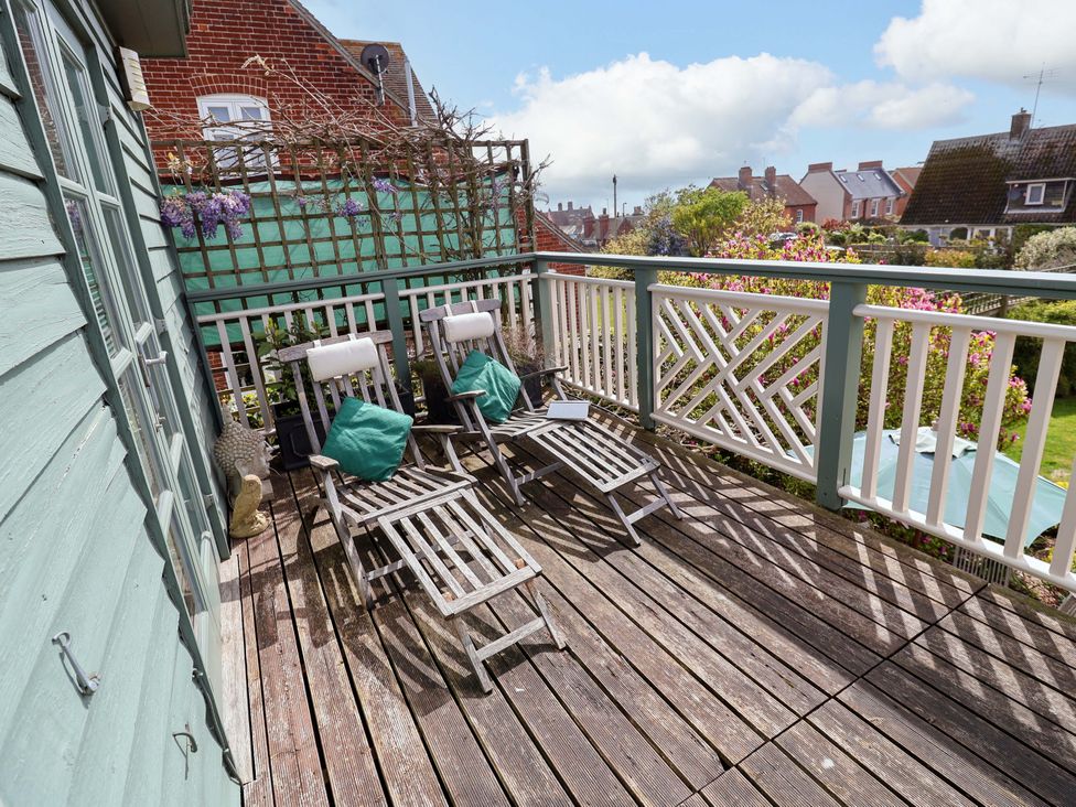 An outdoor deck with chairs and a table at Robert Sadler's Studio in Aldeburgh