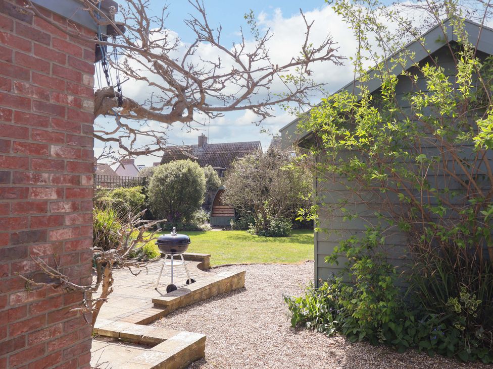 A garden with a brick wall and barbecue grill at Robert Sadler's Studio in Aldeburgh