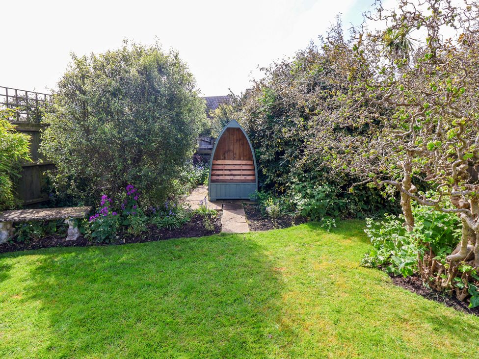 A garden with a bench and shrubs at Robert Sadler's Studio in Aldeburgh