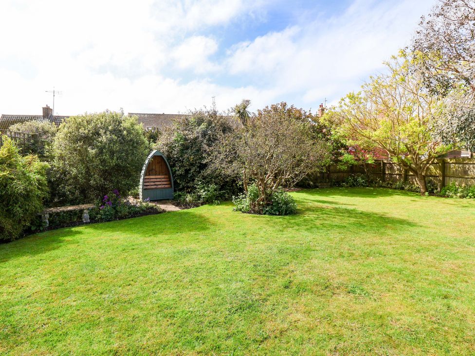 A garden with shrubbery and a seating area at Robert Sadler's Studio in Aldeburgh