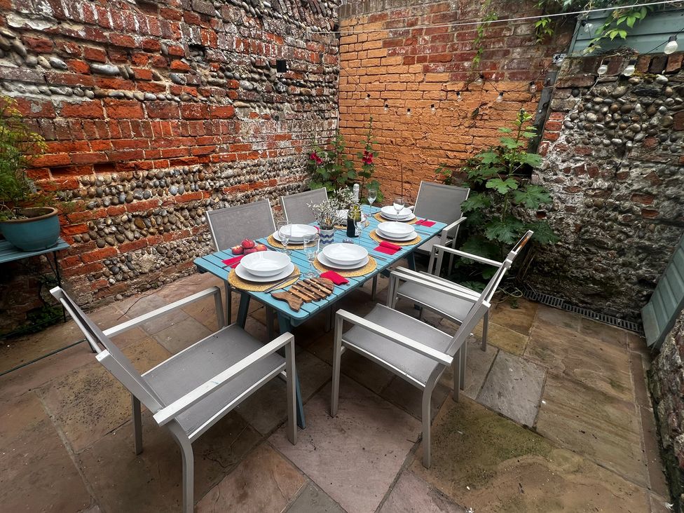 An outdoor dining area with a table set for a meal at Seaflower, Aldeburgh