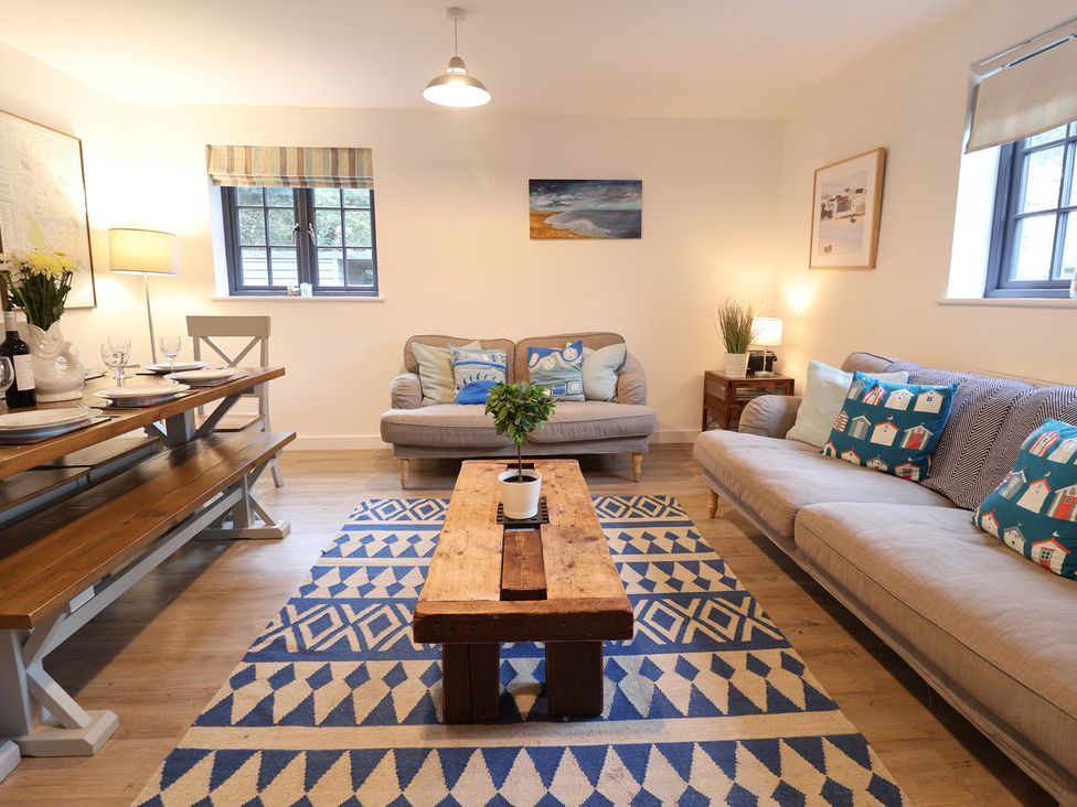 A living room with a sofa and dining table at Corner Cottage, Thorpeness