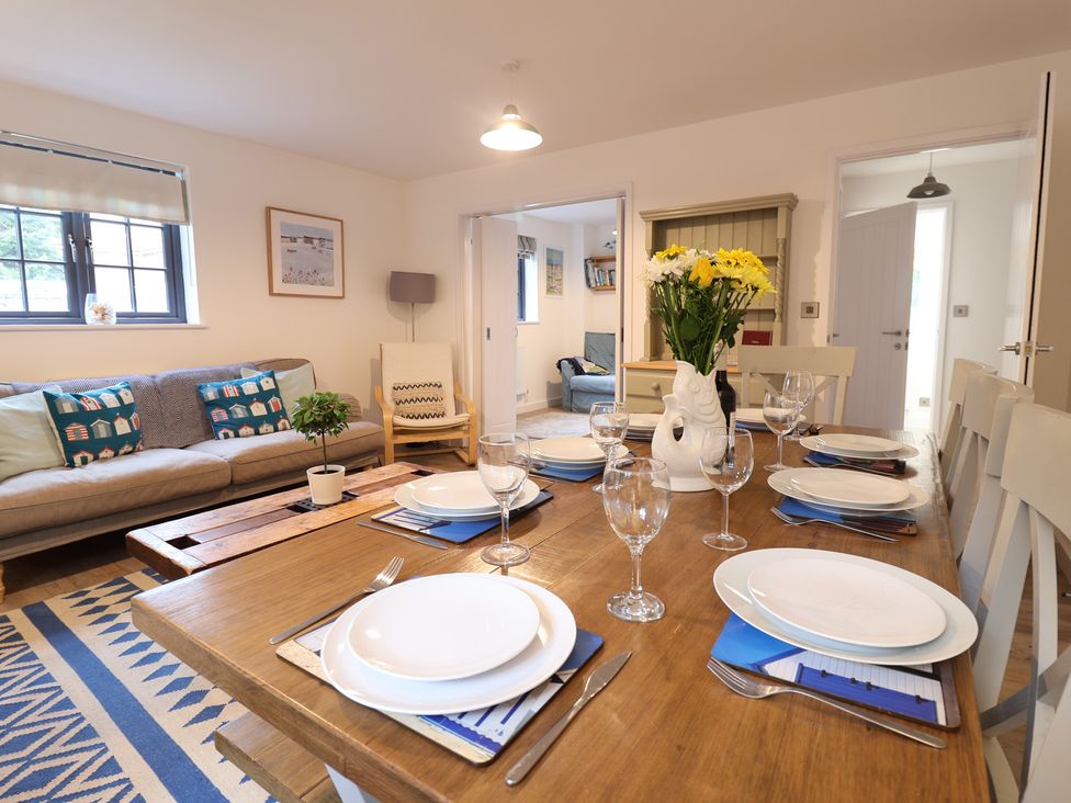 A dining room with a table set for dinner at Corner Cottage, Thorpeness
