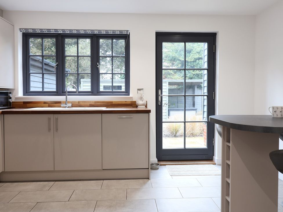 A kitchen with a sink and cabinets at Corner Cottage, Thorpeness